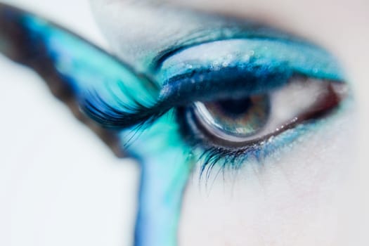 Eye of a young woman with butterfly wings