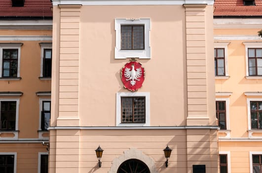 Polish eagle on coat of arms. Front of a traditional polish building.