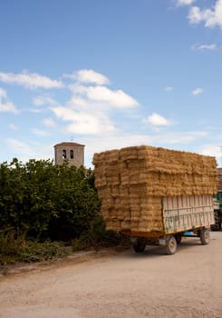 A lot of Bales of hay on the tractor