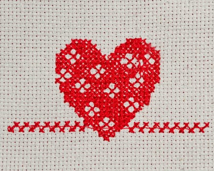 red heart embroidered in cross stitch on  canvas