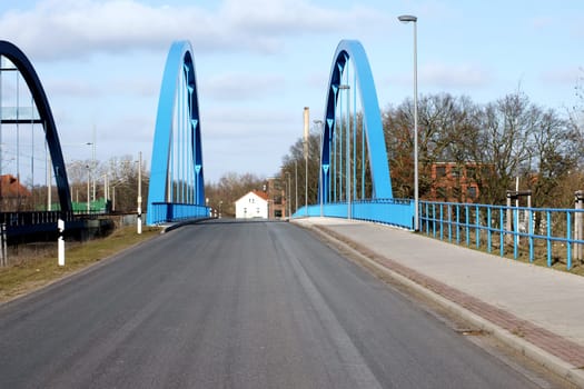 Die Fotografie einer Straßenbrücke (Wittenberge, Brandenburg) und der dazugehörigen Schienenstrecke über dem Fluss Elbe.