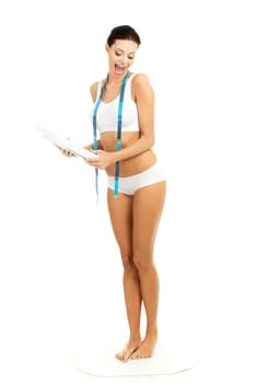 Attractive young woman with measuring tape and scale