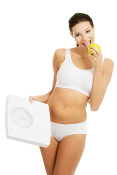 Attractive fit woman with scale and apple, isolated on white