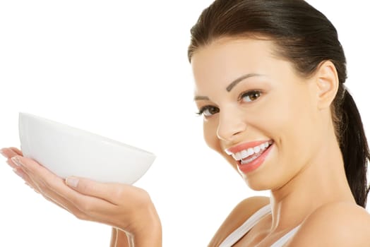 Attractive fit woman holding white bowl, isolated on white