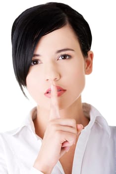 Attractive businesswoman with finger on lips, gesturing for quiet