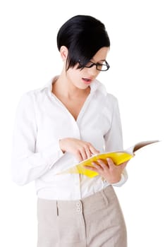 Young focused female reading book, isolated on white