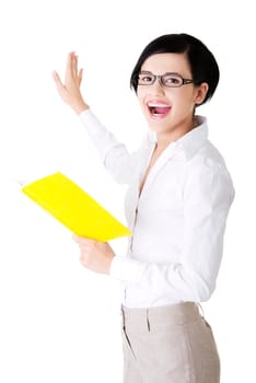 Happy young woman (student or teacher) with book in hand showing on copy space. Isolated on white.