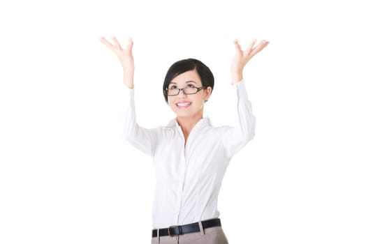 Smiling young woman is holding something abstract above her head. Happy girl with raised hands. Isolated on white background.