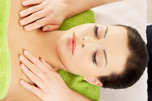 Attractive young woman relaxing beeing massaged in spa saloon