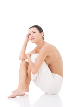 Naked woman covering her self with towel on white background.