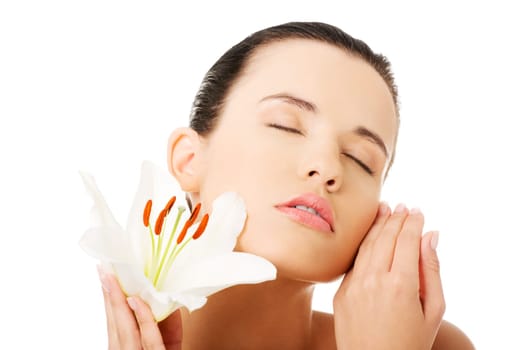 Portrait of beautiful young woman with health skin and with lily flower
