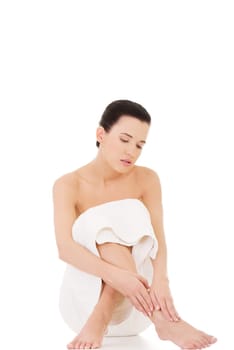 Naked woman covering her self with towel on white background.