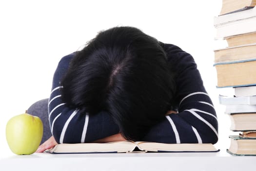 Young woman sleeping on desk next to pile of books, isolated on white