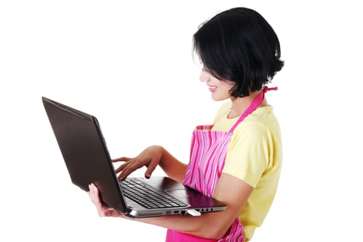 Young woman in pink apron using laptop, isolated on white