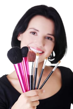 Young make-up artist woman holding brushes