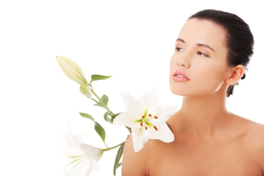 Portrait of beautiful young woman with health skin and with lily flower