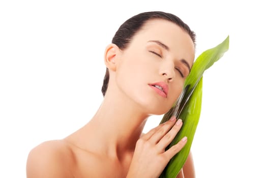 Portrait of young beautiful woman with green exotic leaf