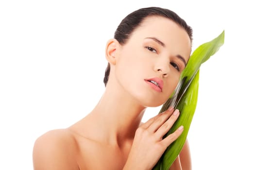 Portrait of young beautiful woman with green exotic leaf