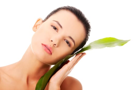 Portrait of young beautiful woman with green exotic leaf