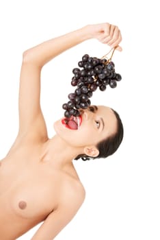 Beautiful sensual brunette eating grapes, isolated on white background