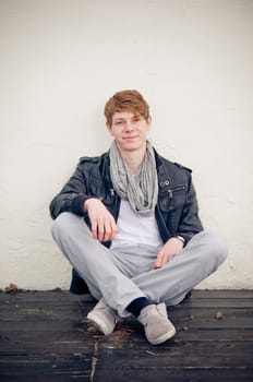 Cool young man sitting on the floor