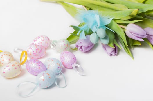 Easter eggs with tulips on light background