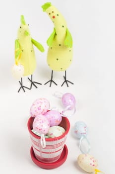 Easter chicken family with eggs on flowerpot on light background