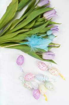 Easter eggs and tulip bouquet on light background