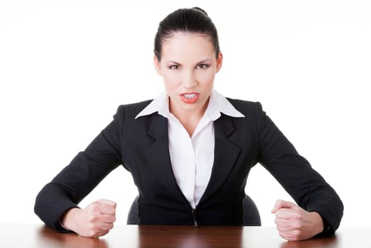 Angry businesswoman at the desk, isolated on white background