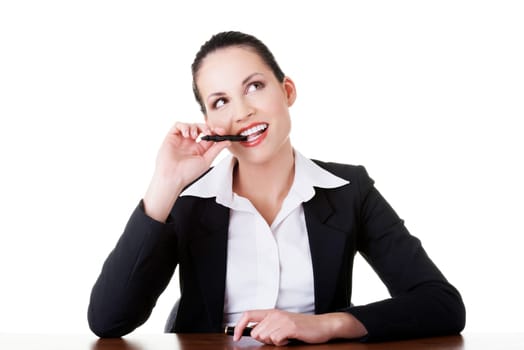 Pretty business woman in sitting at the desk and thinking, isolated on white