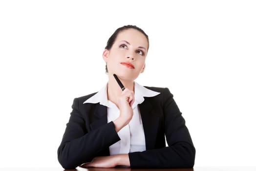 Pretty business woman in sitting at the desk and thinking, isolated on white
