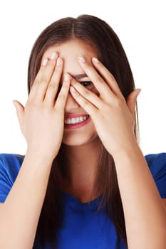 Shy teenage girl peeking through covered face , isolated on white.