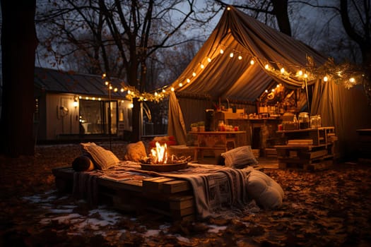 an outdoor living area with a tent, couch and fire pit in the middle part of the yard at night