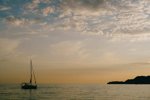 Sailing yacht sails on the sea at sunset. High quality photo