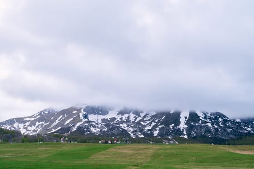 Fog descends over the snowy peaks of the highlands. High quality photo