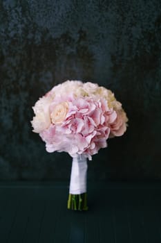 Bridal bouquet is on the floor against the wall. High quality photo