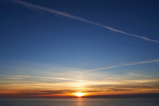 Orange sunset on the blue sky over the sea. High quality photo