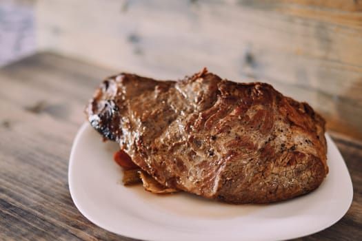 Juicy fried tenderloin with spices and vegetables lies on a plate. High quality photo