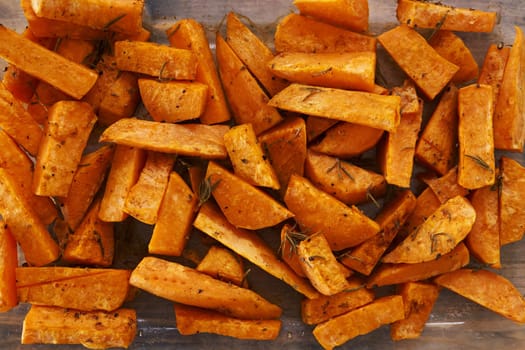 Sliced sweet potato baked with rosemary in a glass dish. High quality photo