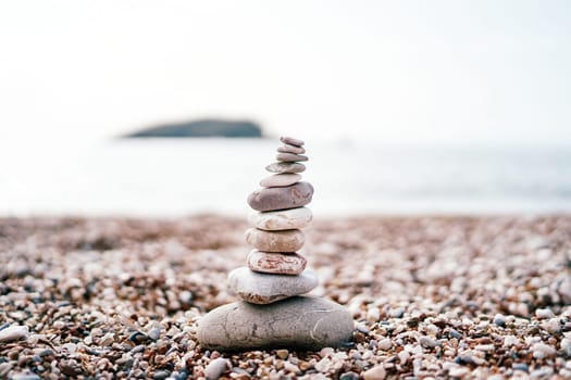 Cairn stands on a pebble beach by the sea. High quality photo