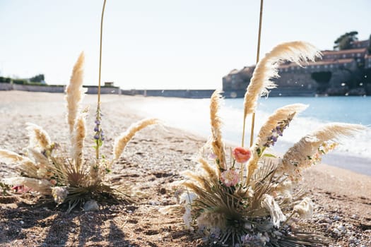 Wedding arch stands on a sunny beach by the sea. High quality photo
