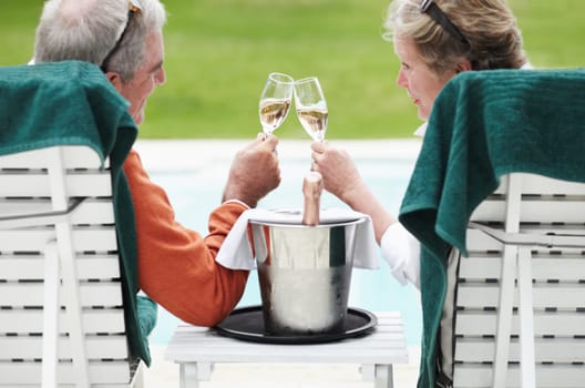 Mature, man and woman with champagne for cheers in celebration of retirement on vacation at resort. Senior couple, love and romance for relationship, bonding and relaxing for quality time together.