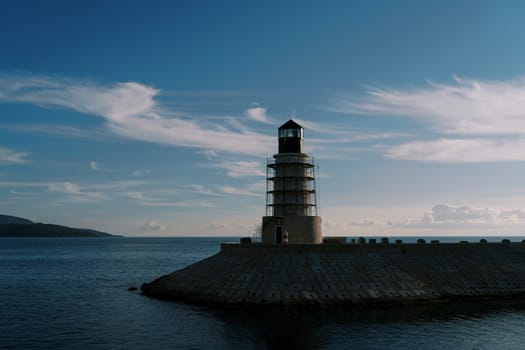 Lighthouse on a breakwater in the sea against the background of a twilight sky. High quality photo