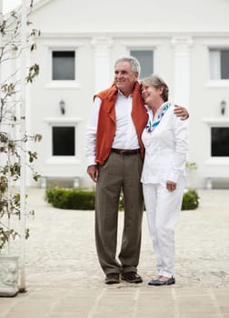 Hug, smile and old couple outside hotel, villa and luxury hospitality on retirement vacation together. Marriage, travel and holiday accommodation, senior man and woman embrace in courtyard in Italy