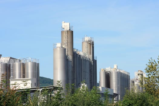 Industrial plant for chemical production,with trees and blue sky