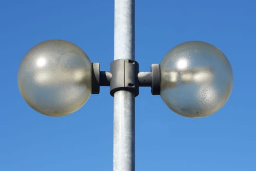 Street lamp with two spotlights,blue sky in the background