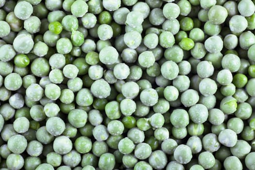 Fresh green peas covered with water drops, food background.