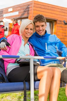 Smiling young couple sitting together on char lift