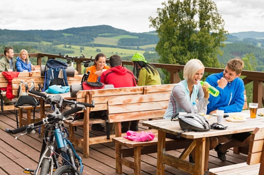 Young people relax mountain holiday summer sport drinking and eating
