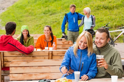 Cheerful people enjoying springtime weekend in rest area drinking beer